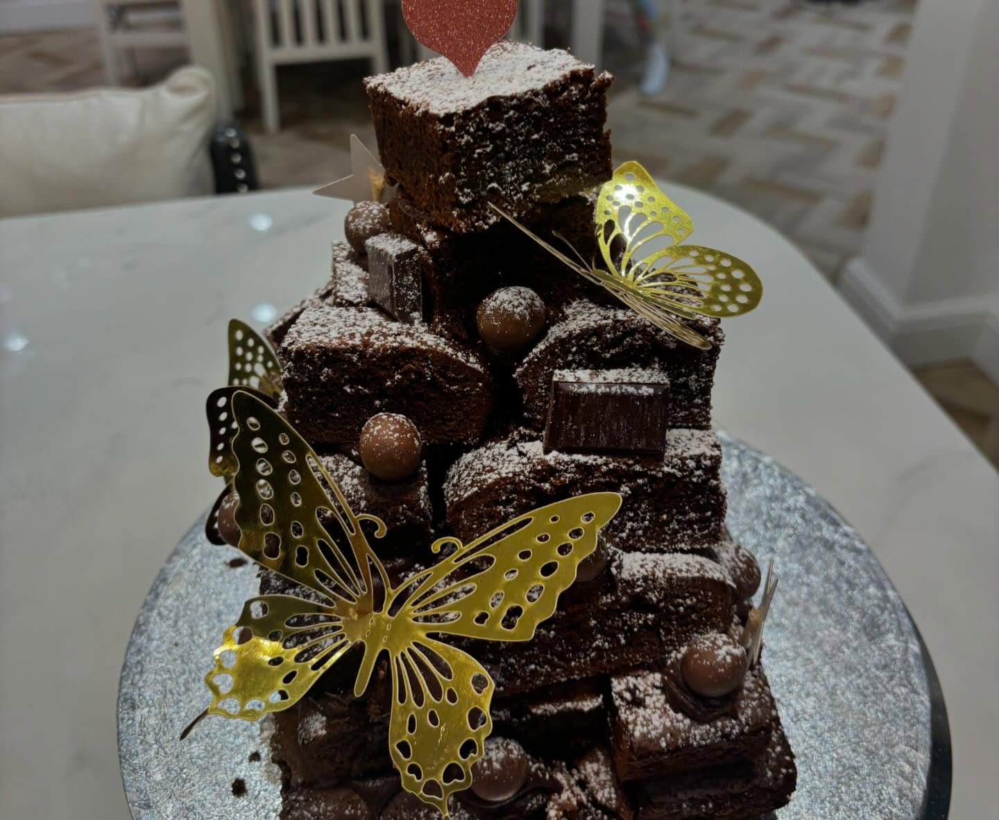 A stack of loaded chocolate brownies with gold butterflies