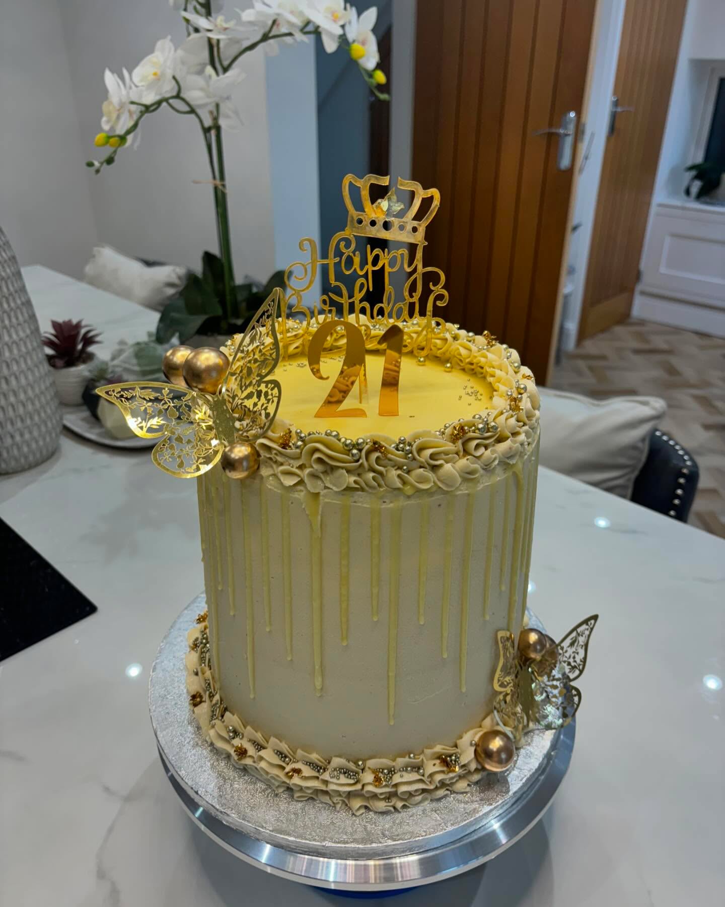 A white and gold drip cake with a Happy Birthday 21 topper by Love At First Bite