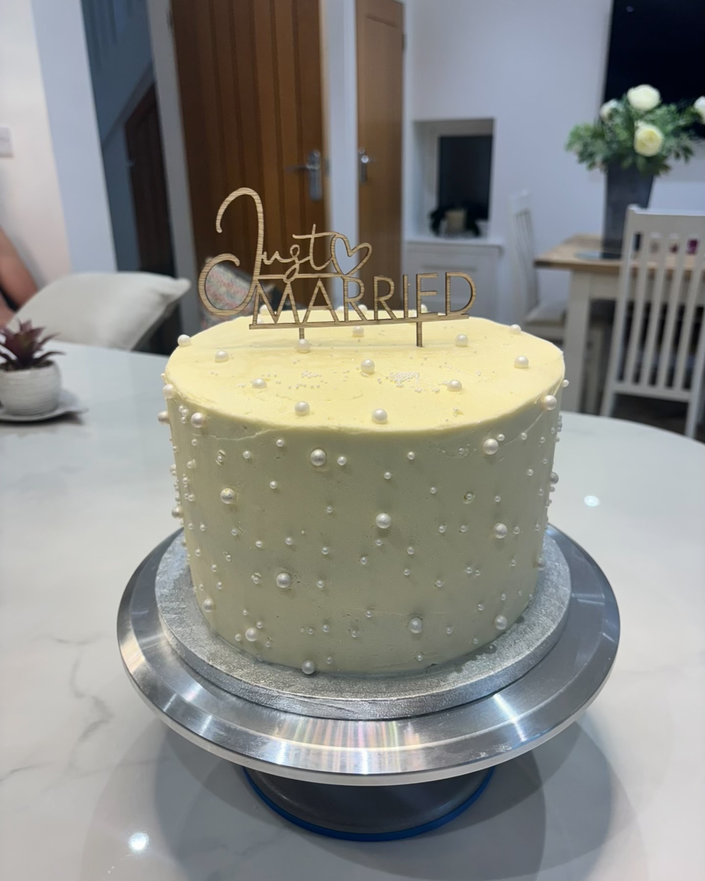 A white pearl wedding cake with a gold Just Married topper